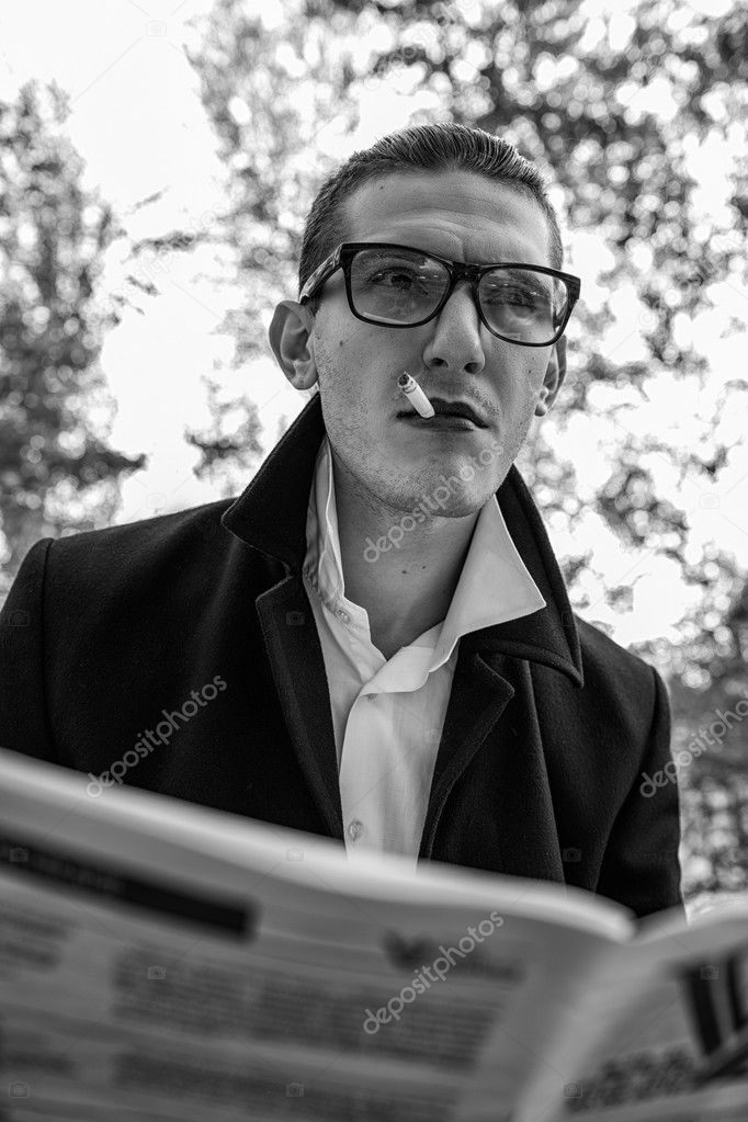 gorgeous guy reading a newspaper and smoking