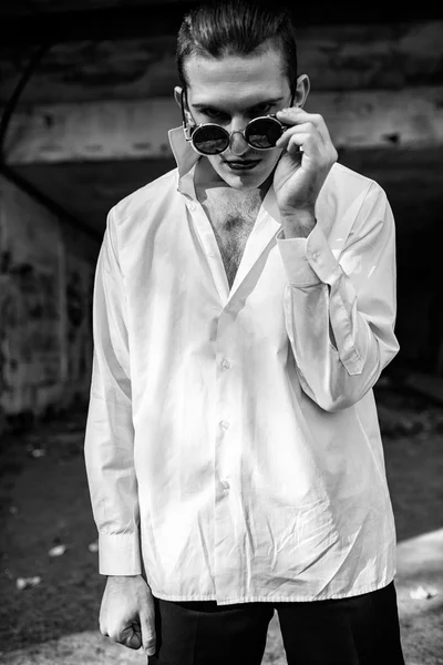 Sexy hombre en una camisa blanca mirando desde debajo de gafas — Foto de Stock