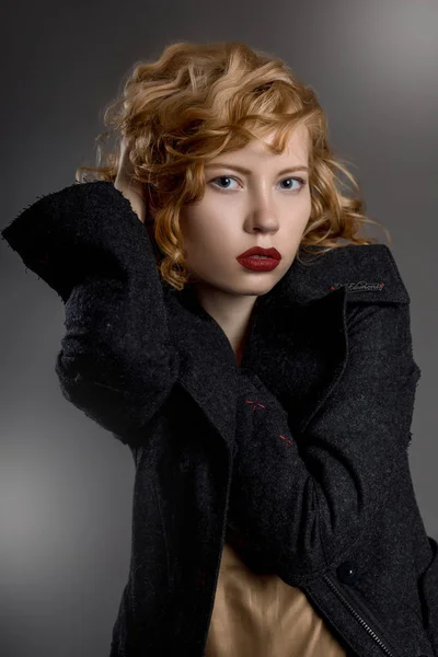 Szexi hosszú lábú lány gyönyörű haj- és gyönyörű szemek, szürke kabátot, gótikus stílusban — Stock Fotó
