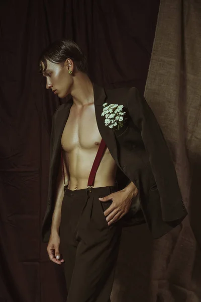 Полуобнаженный сексуальный парень стоит в пиджаке и смотрит в сторону Стоковое Изображение