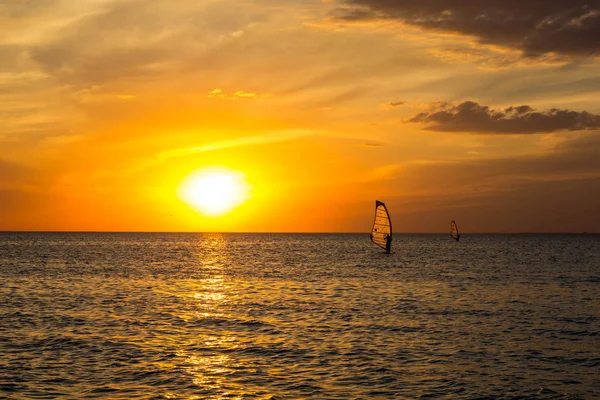 Silueta de un surfista de viento en la puesta de sol olas — Foto de Stock