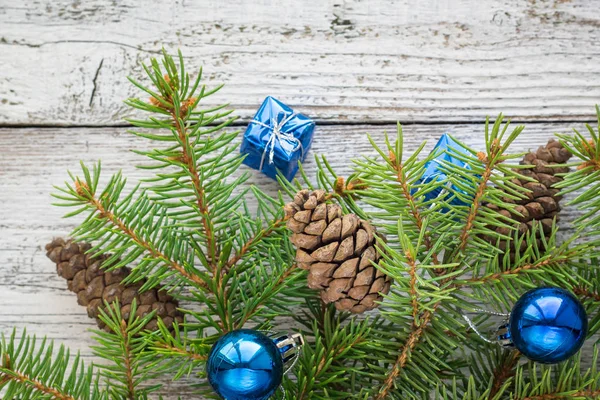 Accesorios navideños en ramas azul y abeto sobre fondo de madera — Foto de Stock