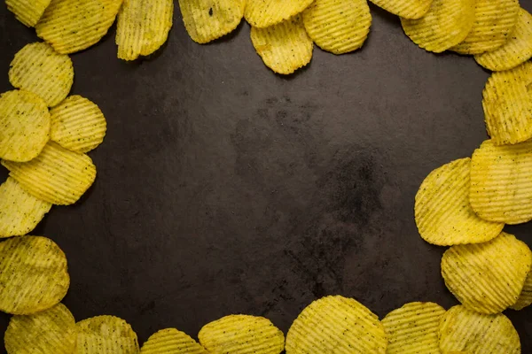Batatas fritas em um fundo escuro — Fotografia de Stock