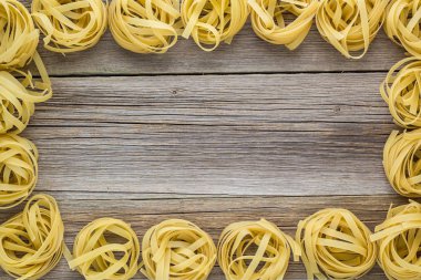 Ham fettuccine makarna ahşap arka plan üzerinde yuva