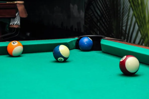 Bolas de bilhar na mesa verde e bola azul no bolso — Fotografia de Stock