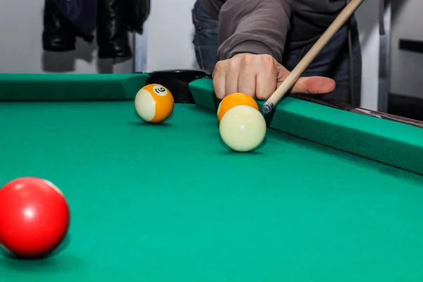 Billiard balls on green table and hand with cue — Stock Photo, Image