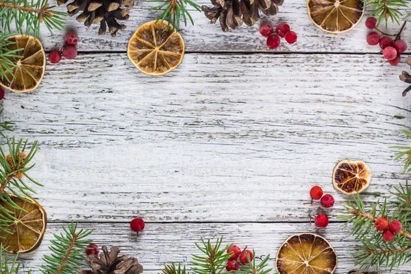 Ramas de Navidad con conos de bayas viburnum y rodaja de limón seco — Foto de Stock