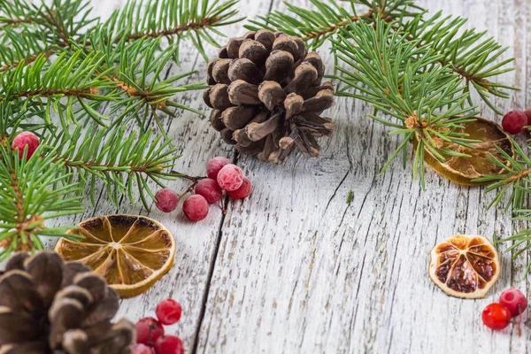 Ramas de Navidad con conos de bayas viburnum y rodaja de limón seco — Foto de Stock