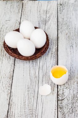 Sepette Beyaz bir arka plan üzerinde beyaz yumurta arasında bir bütün yumurta kırdı