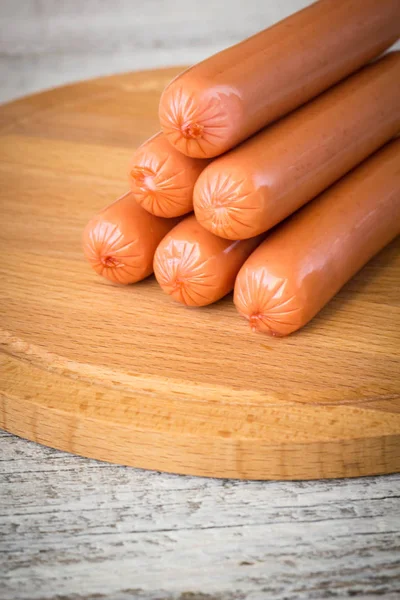 Sausages on rustic wooden background — Stock Photo, Image
