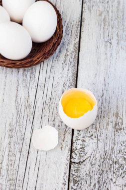 Sepette Beyaz bir arka plan üzerinde beyaz yumurta arasında bir bütün yumurta kırdı