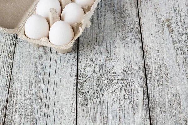 Cardboard egg rack with eggs on wooden table