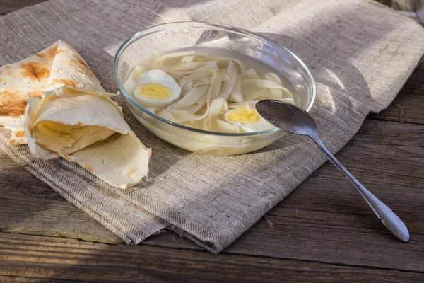 Cup of chicken soup with noodles and eggs — Stock Photo, Image