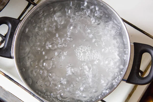 Pentola piena di acqua bollente sui fornelli — Foto Stock
