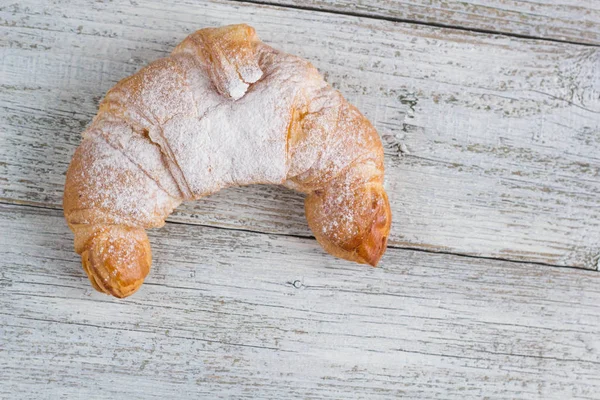 Croissant en la vieja mesa de madera para el desayuno —  Fotos de Stock