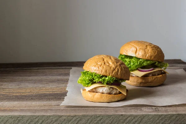 Hecho en casa sabrosas hamburguesas en mesa de madera . —  Fotos de Stock