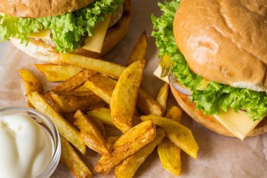 Ev yapımı hamburger tavuk, soğan, salatalık, marul ve peynir ile patates kızartması ahşap tablo