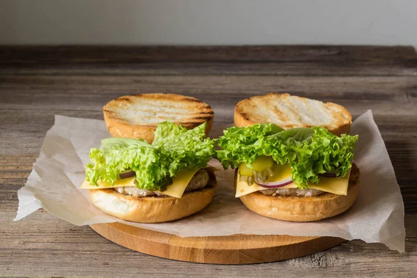 Hecho en casa sabrosas hamburguesas en mesa de madera . —  Fotos de Stock