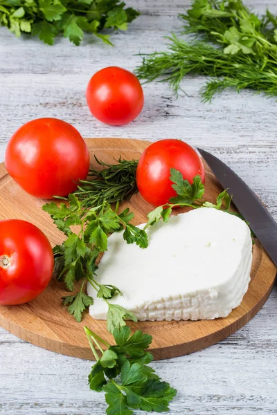 Bílý sýr, nůž, petržel, rajčata na pozadí Dřevěná prkna — Stock fotografie