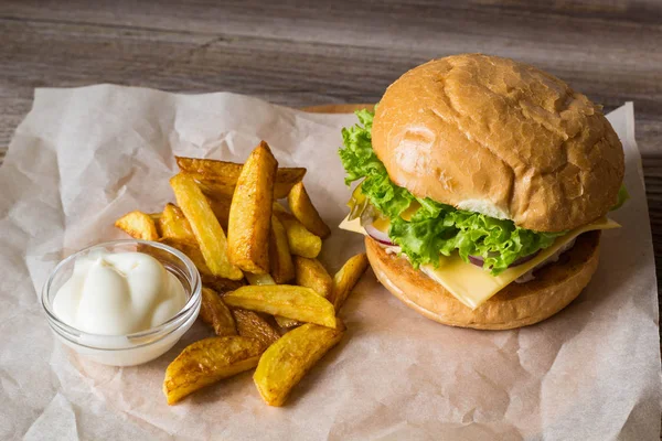 Hamburguesa casera con pollo, cebolla, pepino, lechuga y queso en mesa de madera con papas fritas —  Fotos de Stock