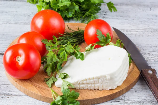 Bílý sýr, nůž, petržel, rajčata na pozadí Dřevěná prkna — Stock fotografie