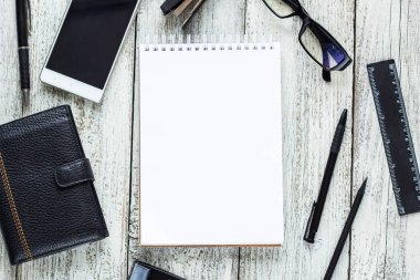 Siyah ve beyaz Natürmort: açılan boş not defteri, defter, kalem, kurşun kalem, gözlük, çanta.