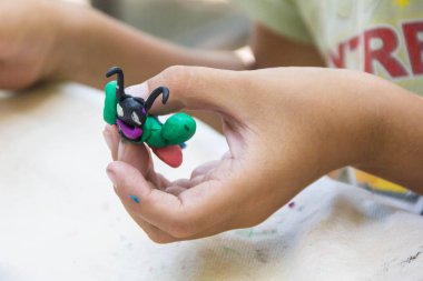 Hayvan figürleri yapmak renkli kil ile oynayan çocuk. closeup ellerinde