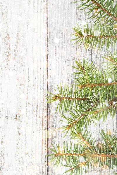 Weihnachten Holzhintergrund mit Tanne, Schnee und Bokeh. Kopierraum von oben — Stockfoto