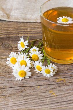 rustik ahşap zemin üzerinde papatya çiçeği ile çay