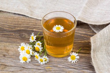 rustik ahşap zemin üzerinde papatya çiçeği ile çay