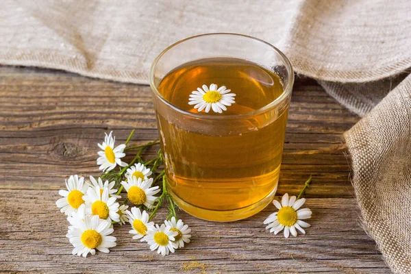 rustik ahşap zemin üzerinde papatya çiçeği ile çay