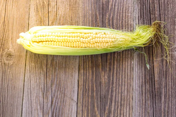 Frischer Mais auf Kolben auf rustikalem Holztisch, Nahaufnahme, Draufsicht, Kopierraum — Stockfoto