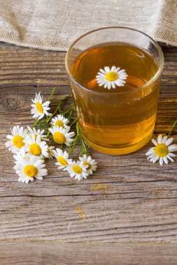 rustik ahşap zemin üzerinde papatya çiçeği ile çay