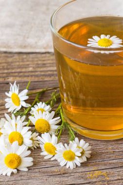 rustik ahşap zemin üzerinde papatya çiçeği ile çay