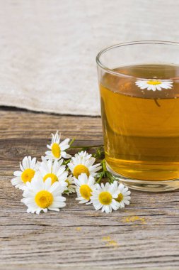 rustik ahşap zemin üzerinde papatya çiçeği ile çay