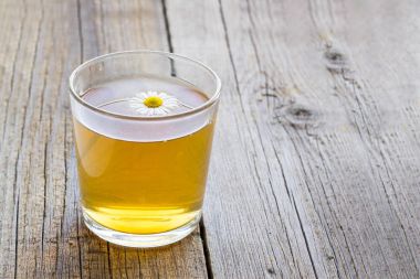 rustik ahşap zemin üzerinde papatya çiçeği ile çay