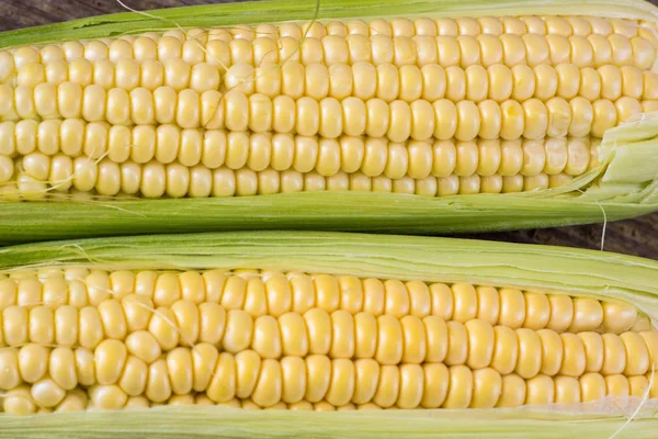 Frischer Mais auf Kolben auf rustikalem Holztisch, Nahaufnahme, Draufsicht, Kopierraum — Stockfoto