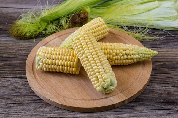 生鲜玉米放在粗糙的木桌上，特写 — 图库照片