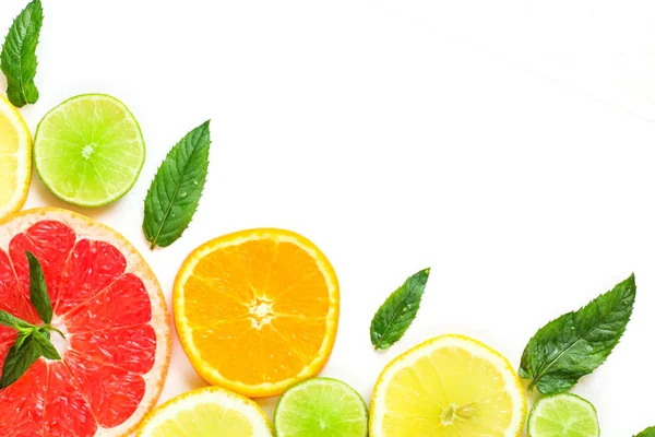 Цитрусовый пищевой уголок на белом фоне - различные цитрусовые фрукты с листьями мяты. Изолированный на белом фоне — стоковое фото
