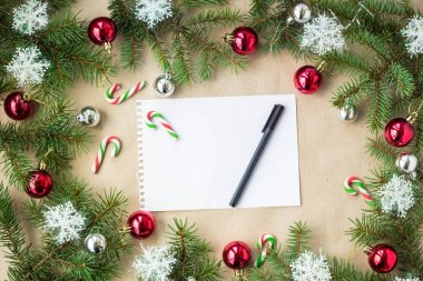 Çam dalları üzerinde kırmızı ve gümüş top ve rustik bej renkli arka plan üzerinde kar taneleri ile şenlikli Noel sınır