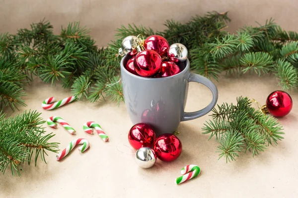 Silver and red christmas decorations balls in cup with fir tree christmas background — Stock Photo, Image