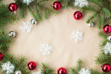 Çam dalları üzerinde kırmızı ve gümüş top ve rustik bej renkli arka plan üzerinde kar taneleri ile şenlikli Noel sınır