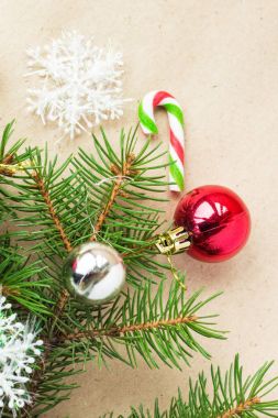 Çam dalları üzerinde kırmızı ve gümüş top ve rustik bej renkli arka plan üzerinde kar taneleri ile şenlikli Noel sınır