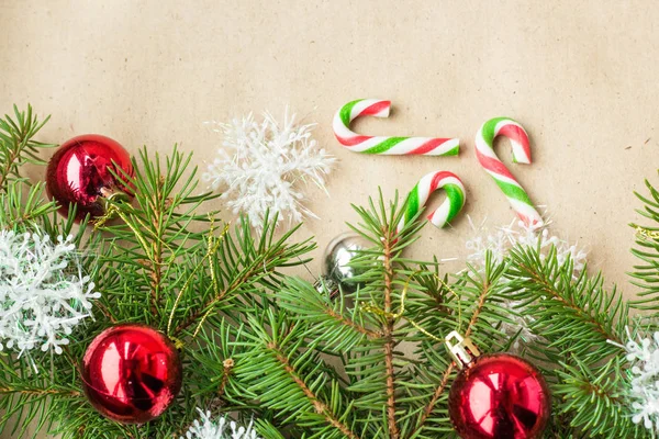 Slavnostní vánoční hranice s červené a stříbrné kuličky na větvích jedlí a sněhové vločky na rustikální béžové pozadí — Stock fotografie