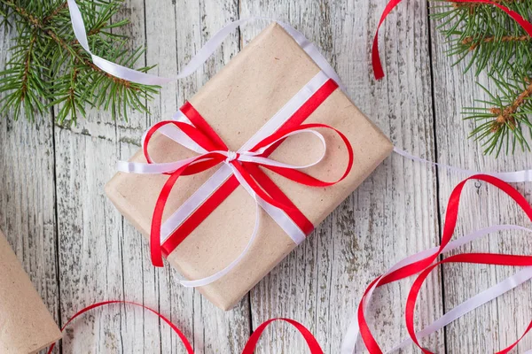 Embalagem Presentes de Natal em papel kraft com fitas vermelhas e brancas — Fotografia de Stock