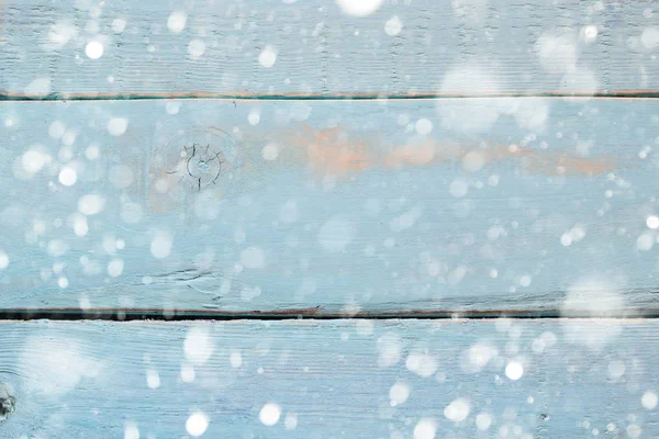 Vintage blue wooden table with snow background