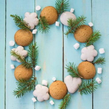 Noel ahşap arka plan ağaç dalları, zencefilli kurabiye ve krema ile