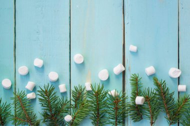 Çam ağacı ve ahşap arka plan üzerinde marshmallows dalı ile Noel sınır