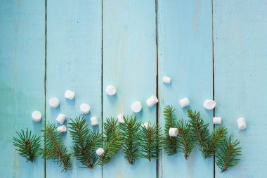 Çam ağacı ve ahşap arka plan üzerinde marshmallows dalı ile Noel sınır