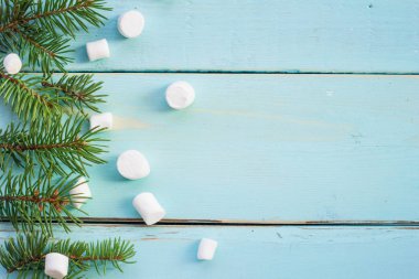 Çam ağacı ve ahşap arka plan üzerinde marshmallows dalı ile Noel sınır